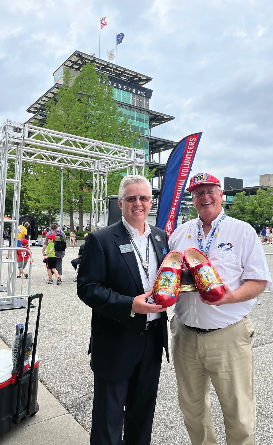 During the 500 Festival Volunteer Program presented by Citizens Energy Group Appreciation Day at the Indianapolis Motor Speedway, 500 Festival CEO Bob Bryant and AES 500 Festival Parade Co-Chair Mark Eutsler hold a plaque containing a pair of wooden shoes like those worn by members of the Holland, Michigan HS Marching Dutchman Band to commemorate Eutsler’s more than a quarter-century as parade co-chair and 35 years as a 500 Festival volunteer. Eutsler told Bryant his earliest childhood memories of the parade include the distinct sound of the wooden shoes on the downtown Indianapolis streets and on the Indianapolis Motor Speedway during the Indy 500 Parade of Bands preceding the race each year, and how the sound was muffled when the band marched onto the checkered carpet that covered one block of Pennsylvania Street curb to curb. The Marching Dutchman band has made several appearances in both events since the 1960s.